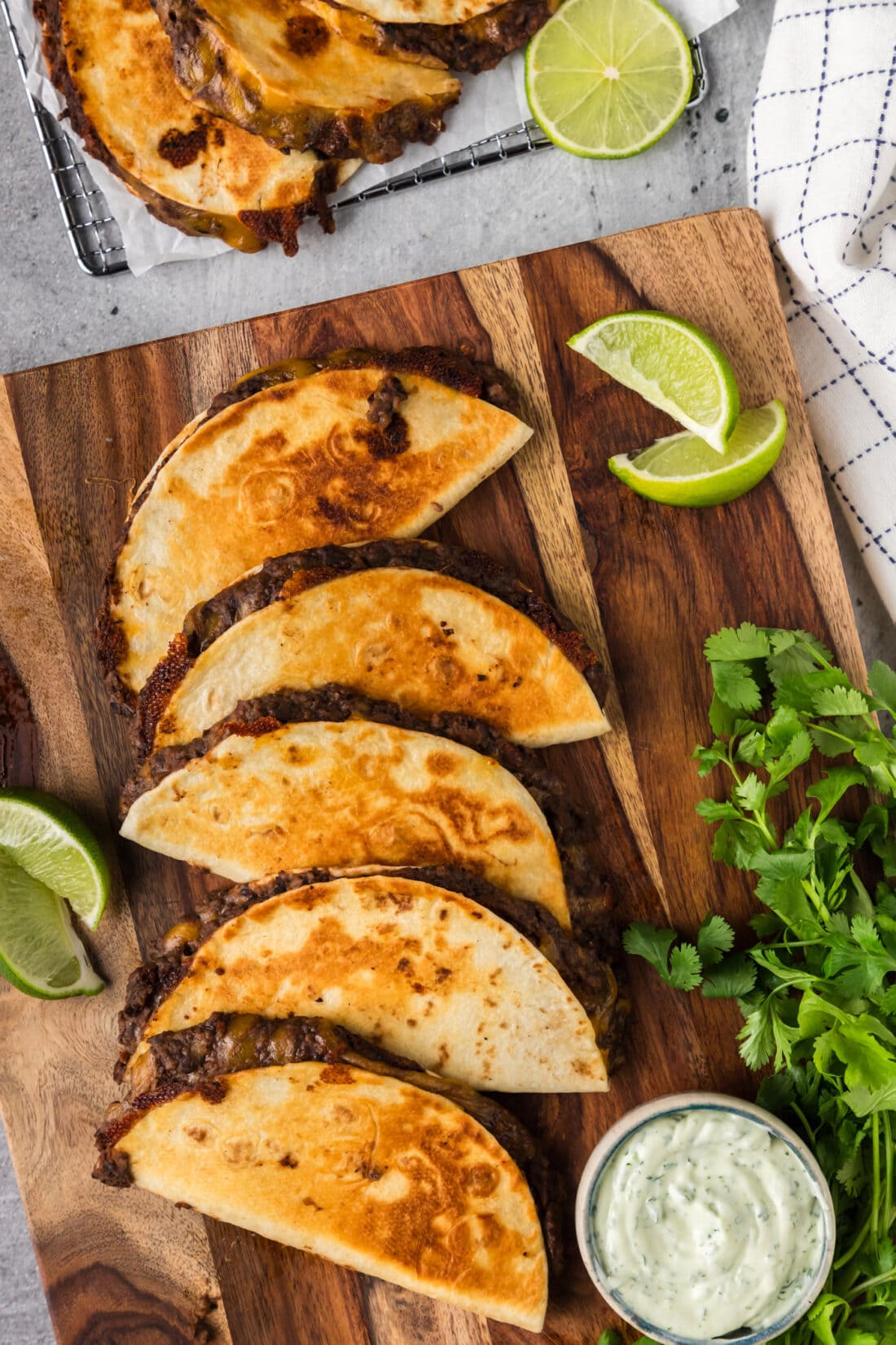 Black Bean Tacos on a wooden board with limes and dipping sauce