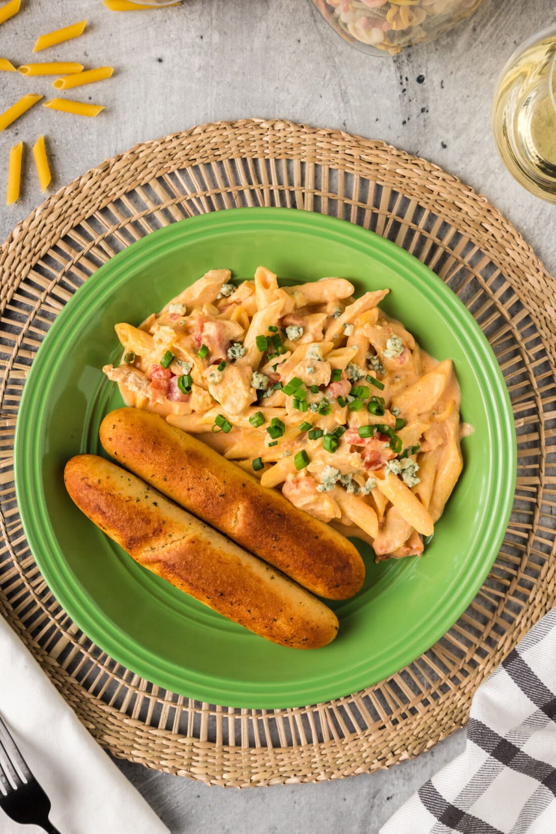 Buffalo Chicken Pasta on a plate with breadsticks