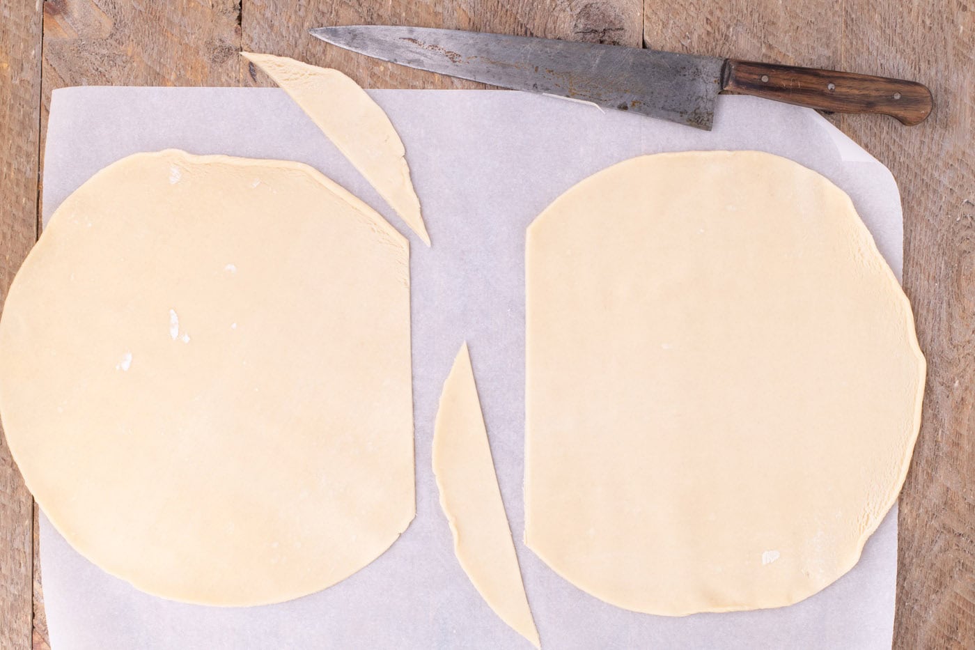 trimmed premade pie crust on parchment paper