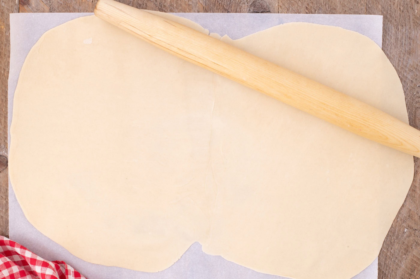 rolling together premade pie crusts with a rolling pin