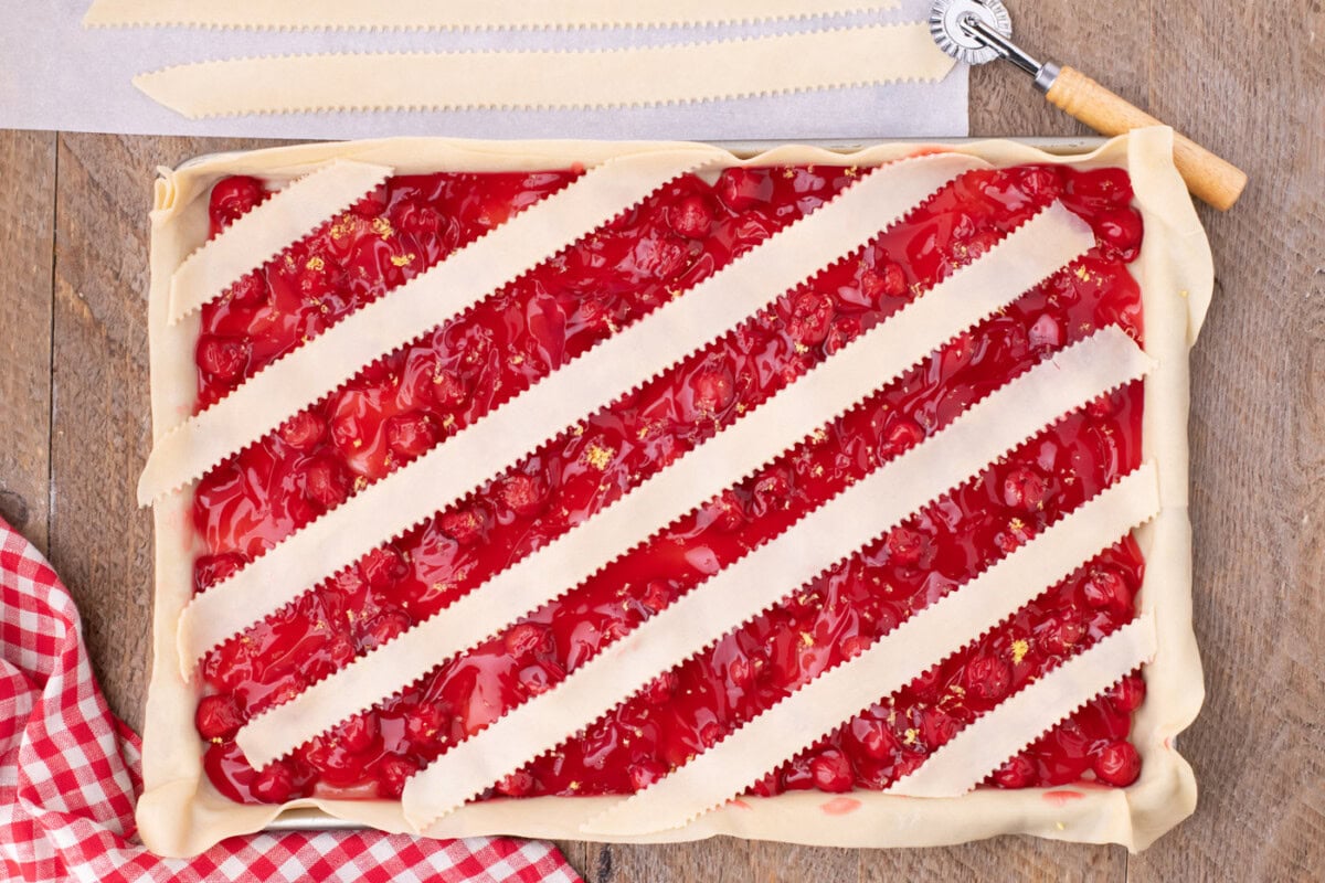 layering strips of pie crust over slab pie horizontally