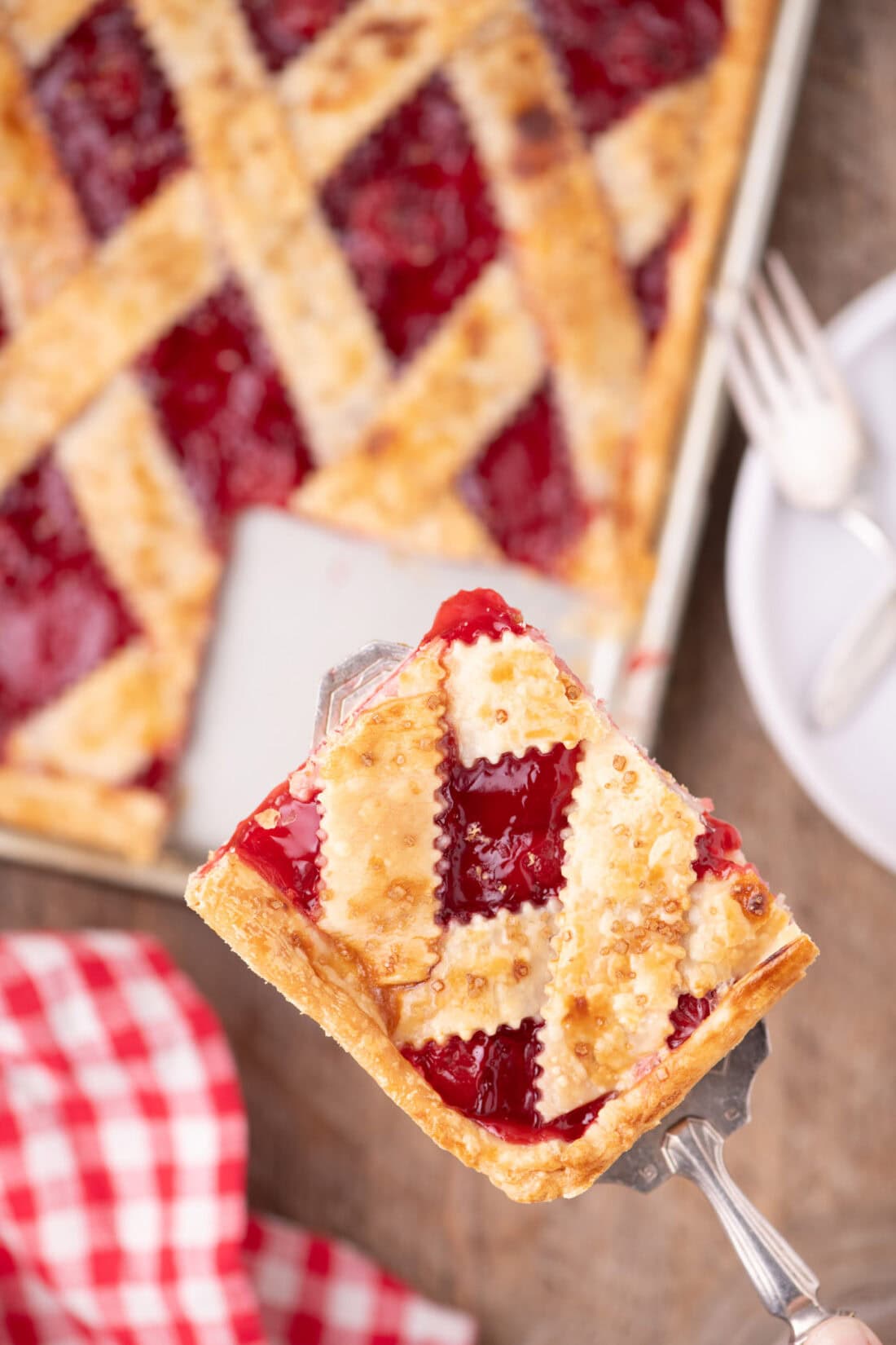 Spatula holding a square of Cherry Slab Pie above the rest of the Cherry Slab Pie