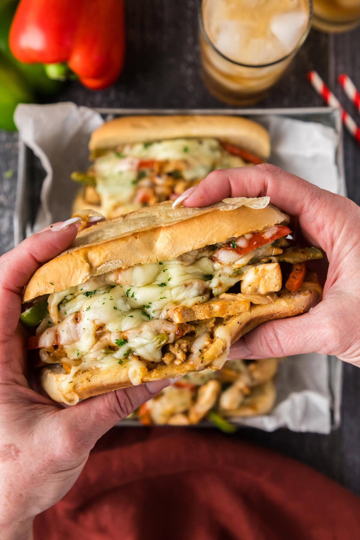 Hands holding a Chicken Philly Cheesesteak