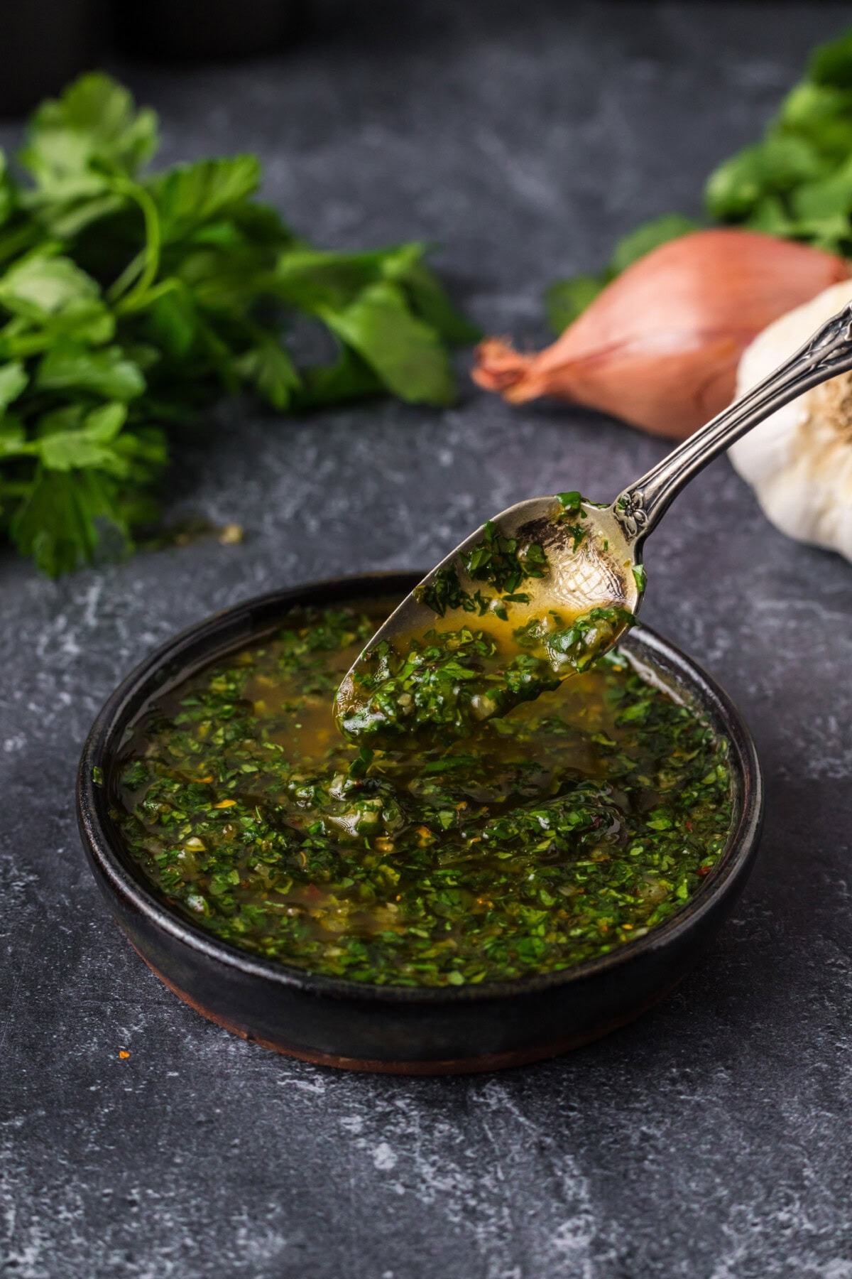 Spoon drizzling Chimichurri into a bowl of Chimichurri