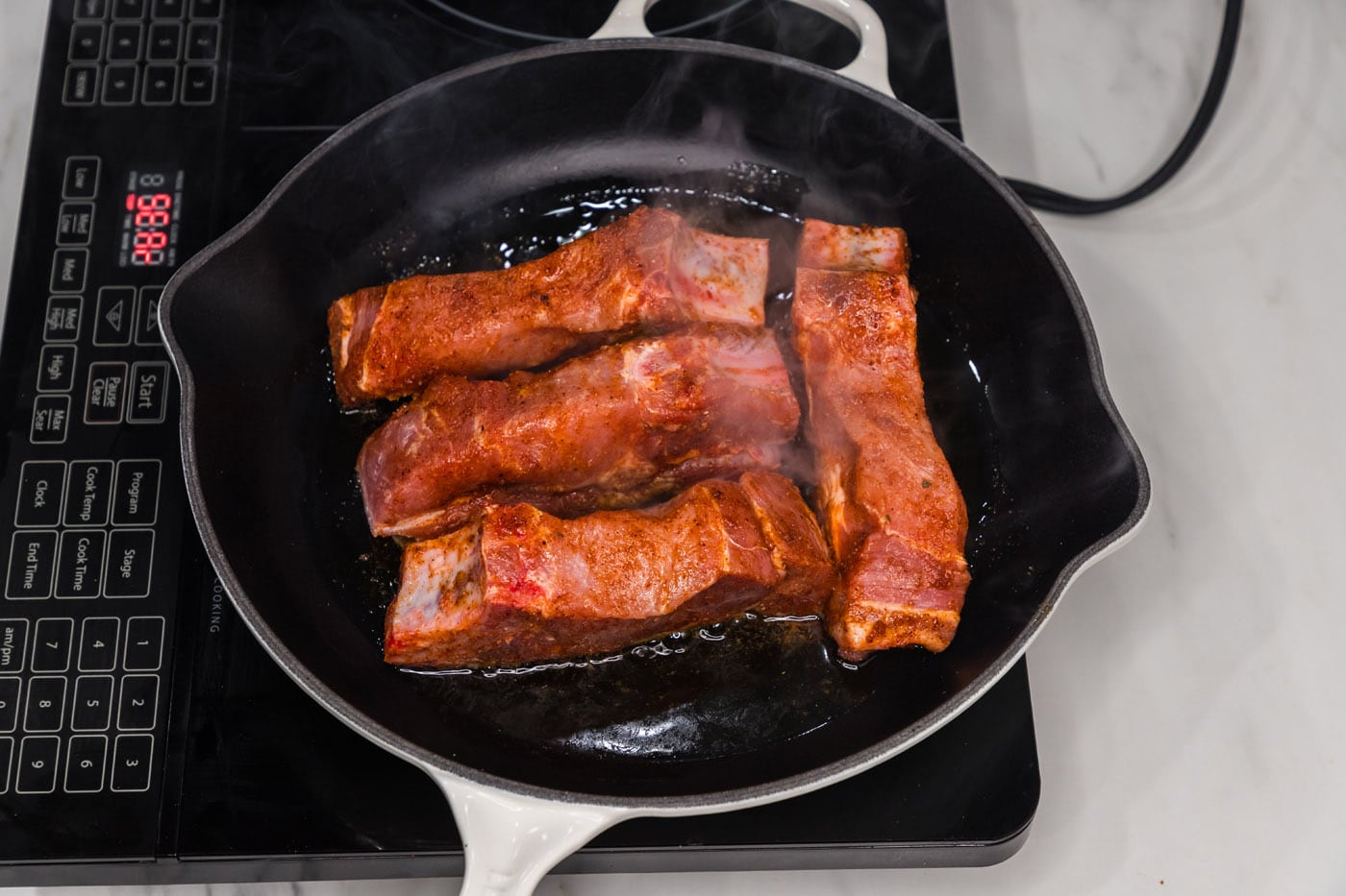 searing ribs in a skillet