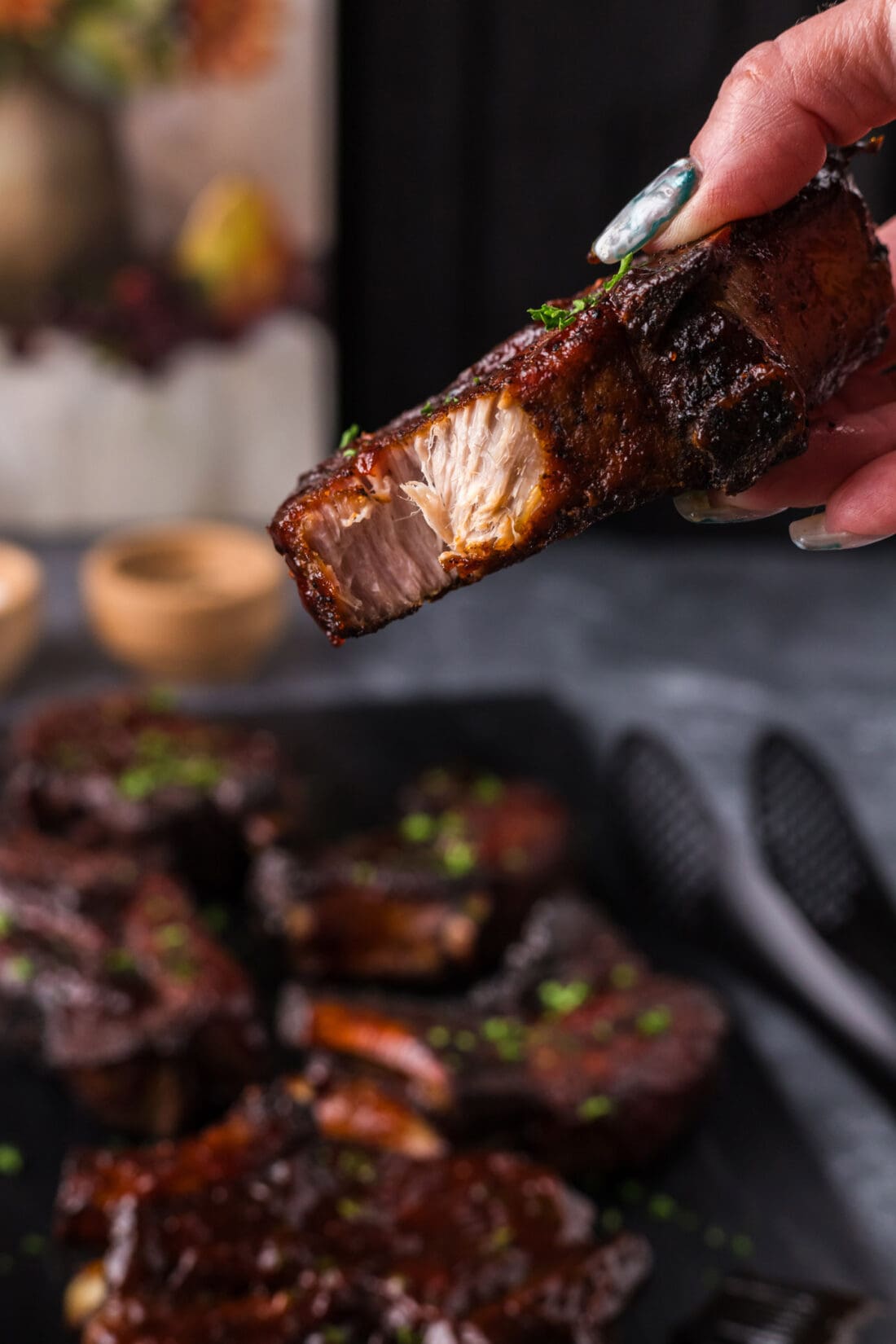 Hand holding up a Country Style Rib with a bite taken out