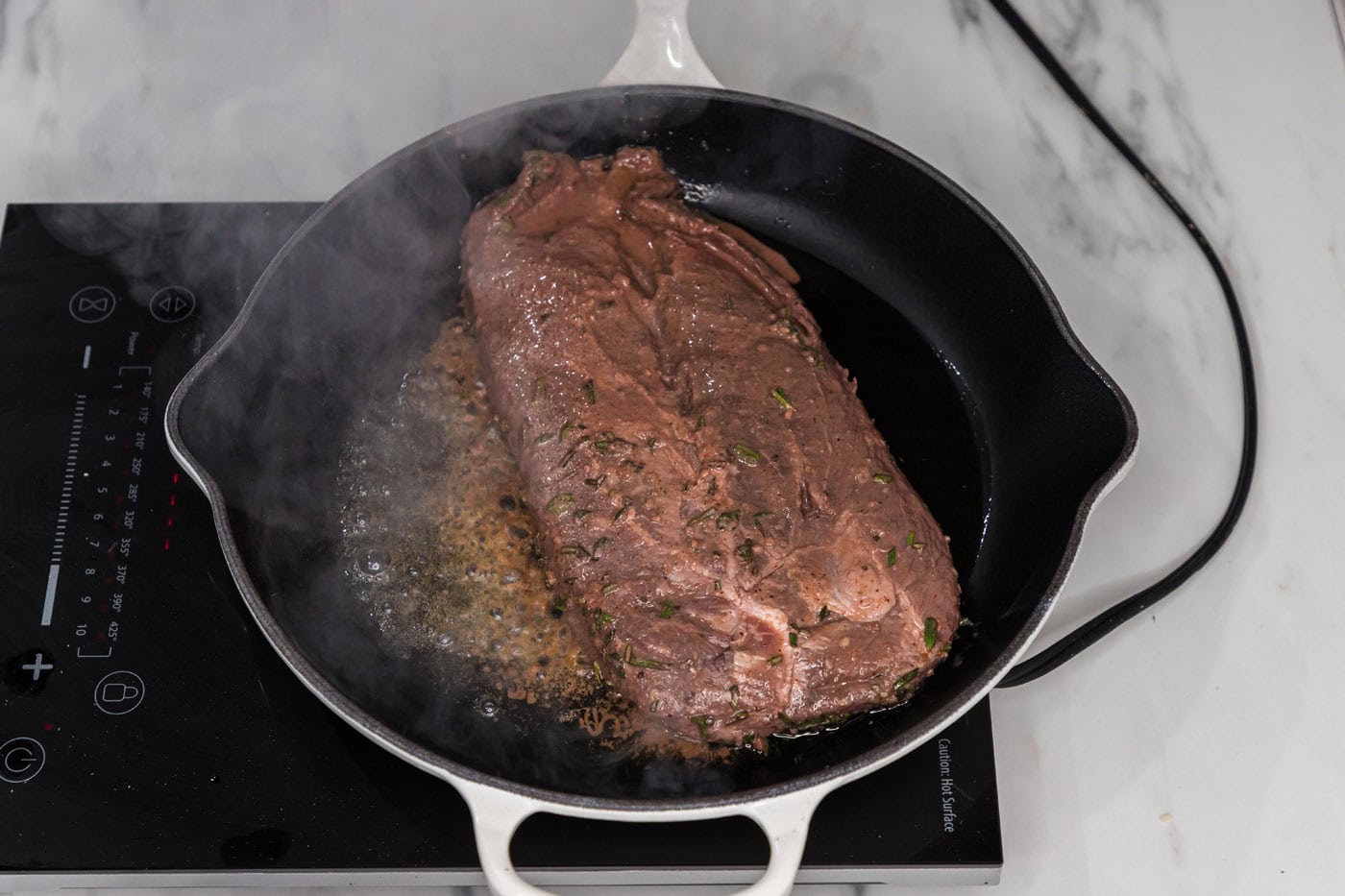 searing flat iron steak in a skillet