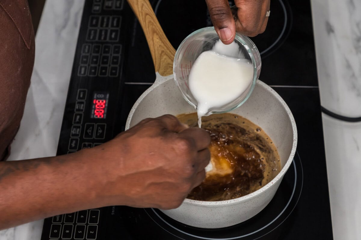 whisking cornstarch slurry into honey garlic sauce in a saucepan