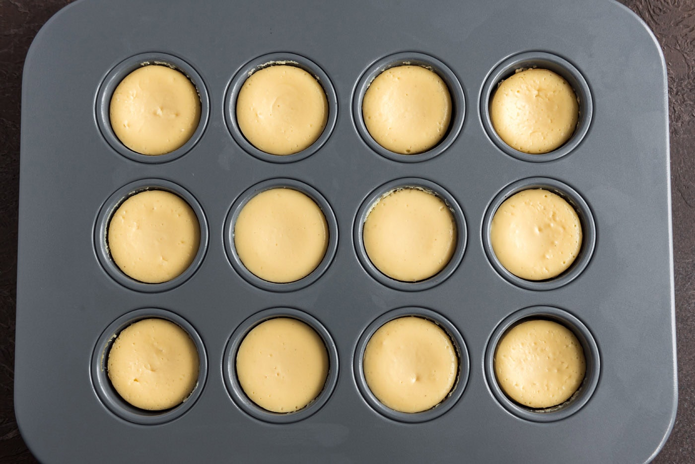 overhead shot of baked mini cheesecakes in a pan