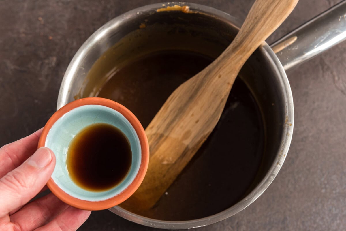 adding vanilla to homemade caramel in a saucepan