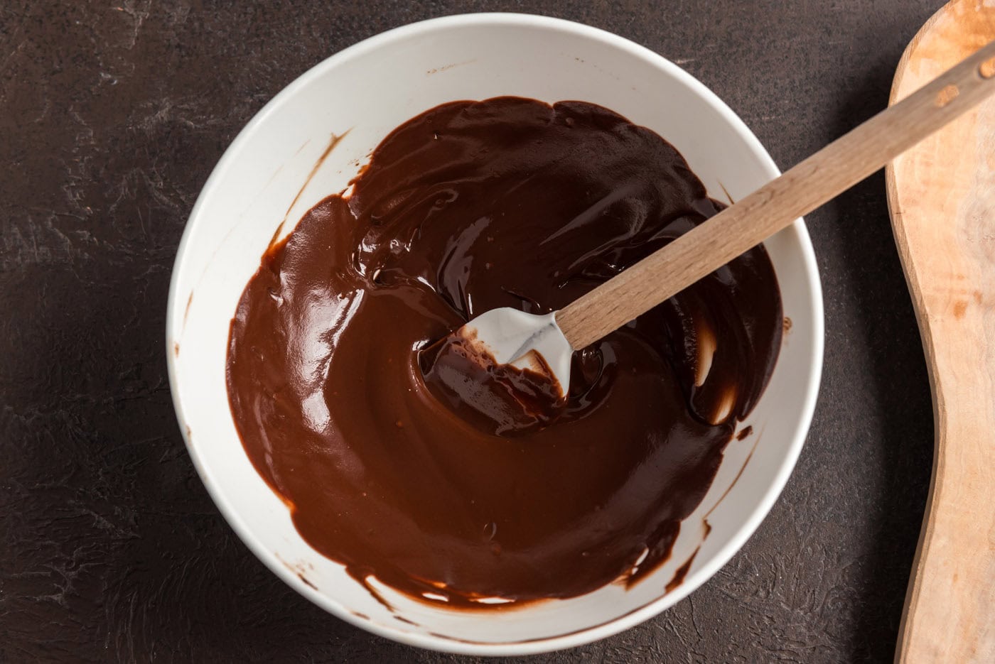 melted chocolate in a bowl with a rubber spatula