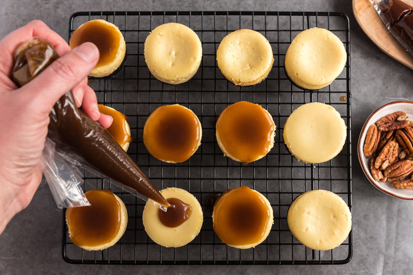 pooling caramel over mini cheesecakes