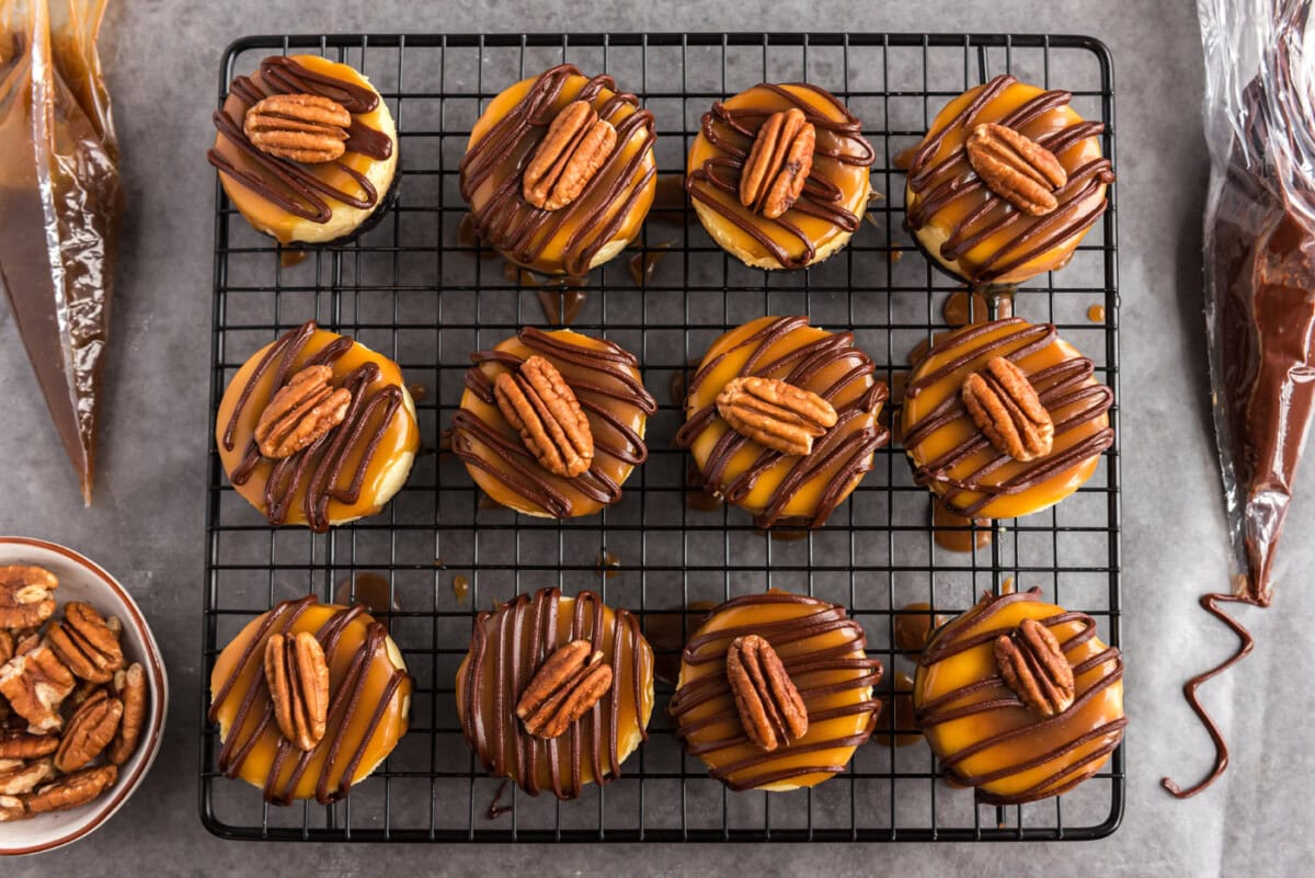 mini turtle cheesecakes on a wire baking rack with whole pecans