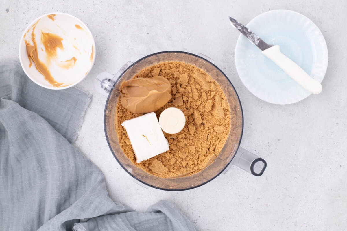 cream cheese and creamy peanut butter added to nutter butter cookie crumbles in a food processor