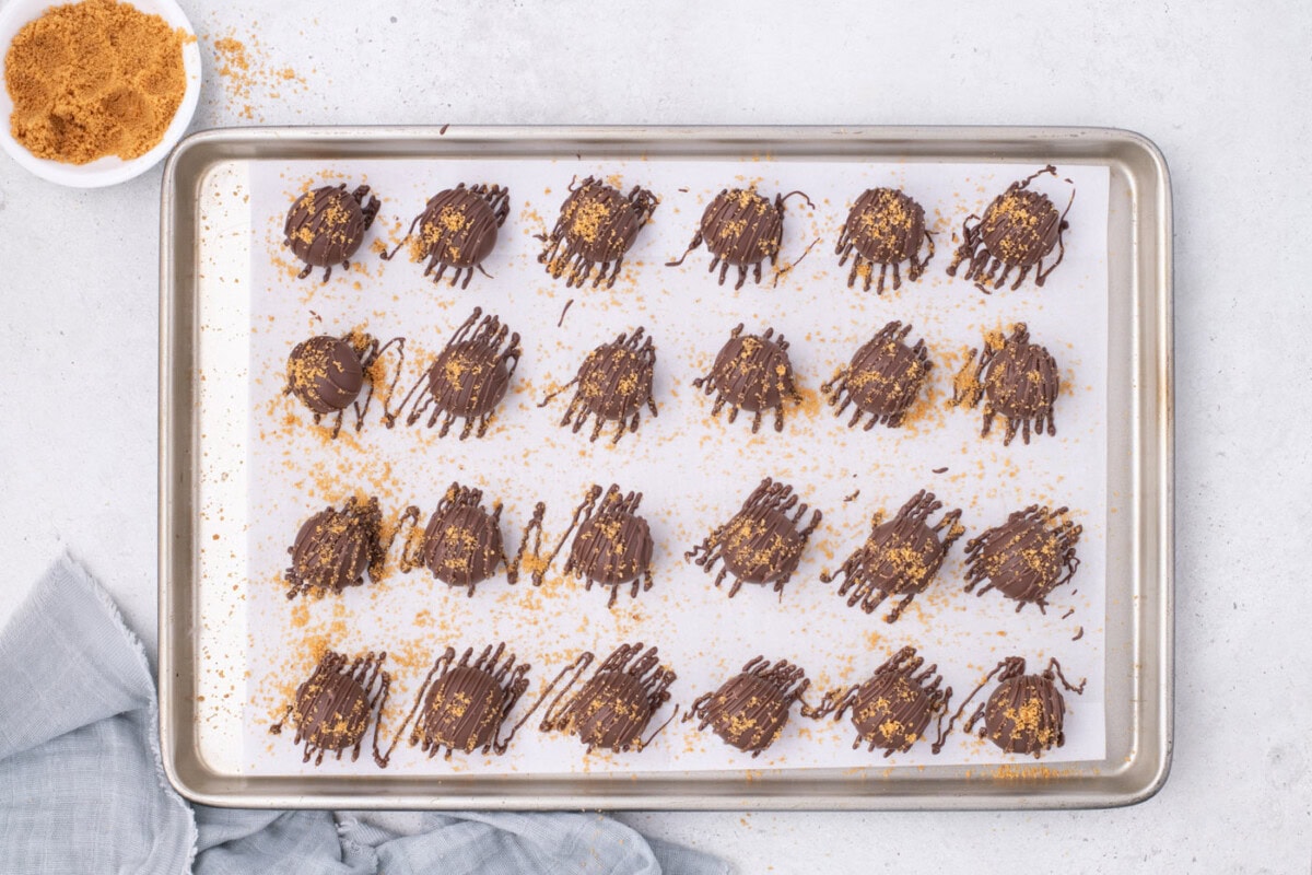 drizzled and garnished nutter butter balls on a baking sheet