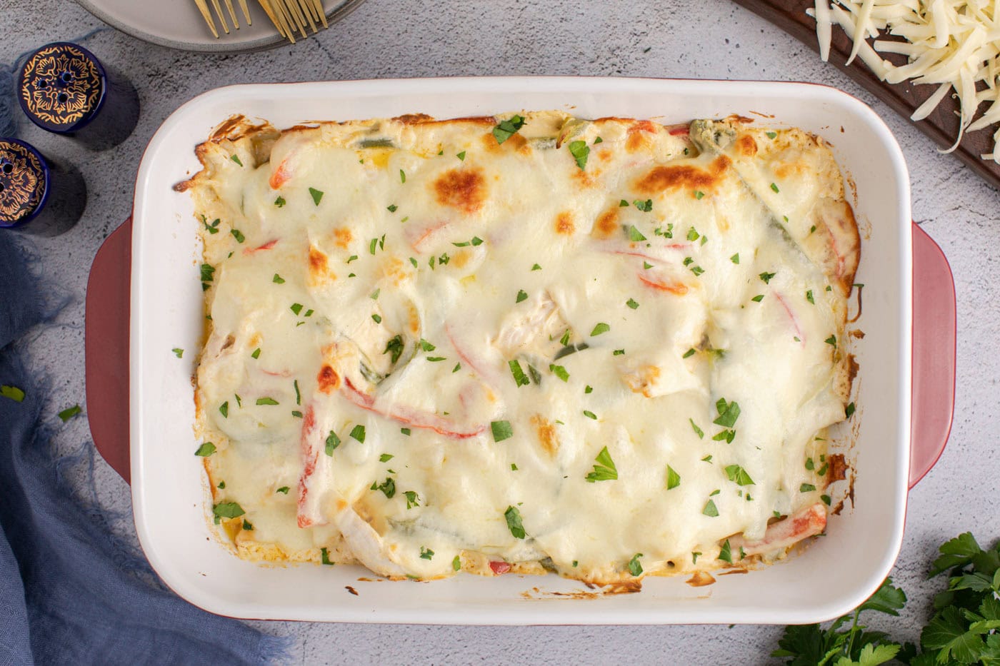 bubbly chicken philly cheesesteak casserole with chopped parsley as garnish
