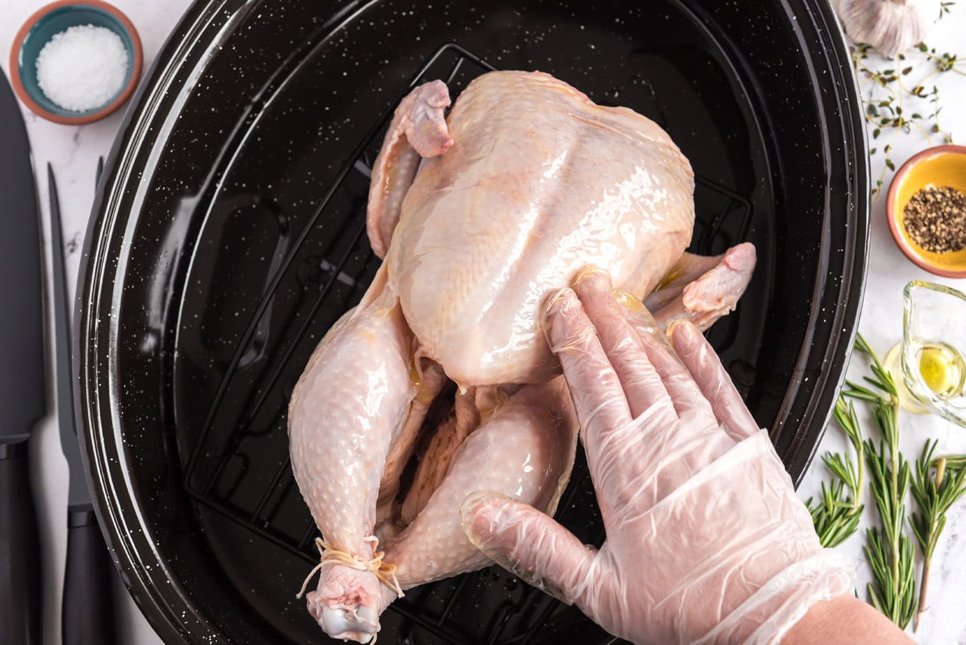 rubbing chicken with olive oil in a roasting pan