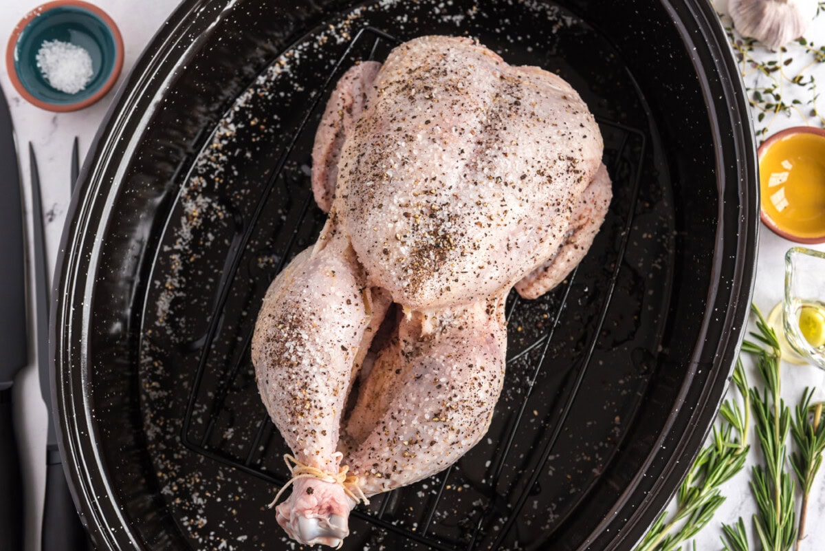 whole raw chicken rubbed with olive oil, salt, and pepper