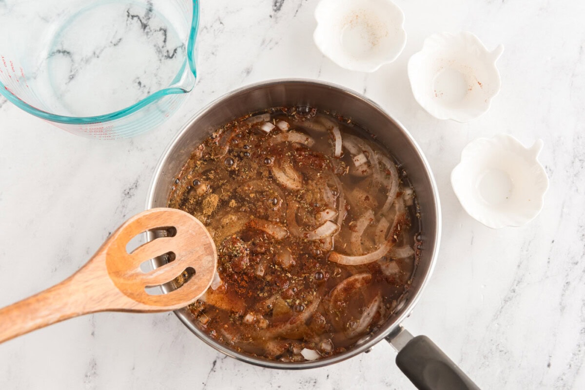 reducing onion and chicken broth mixture in a saucepan
