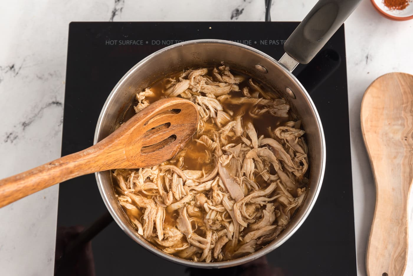 shredded chicken added to pot with chicken broth mixture