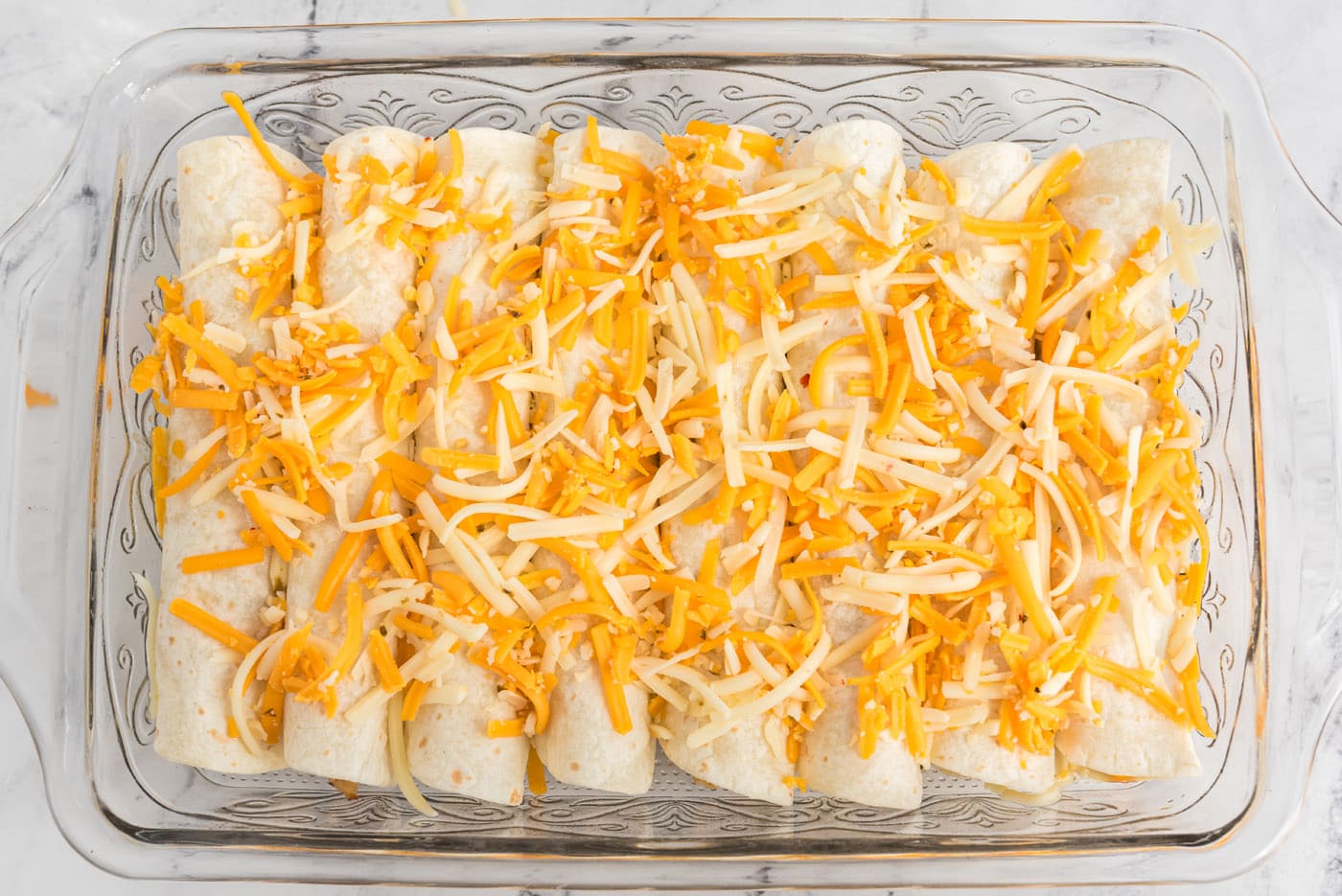 enchiladas topped with shredded cheese