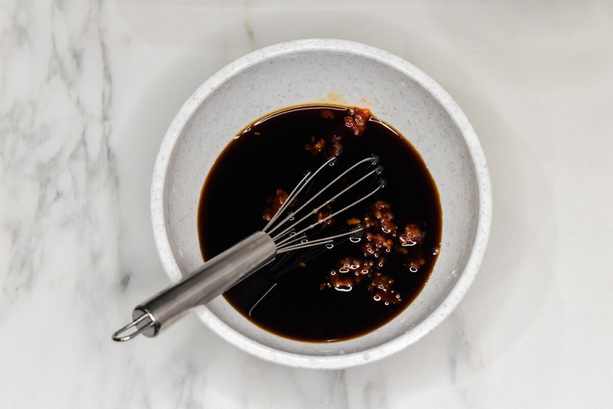 pad thai sauce in a bowl with a whisk