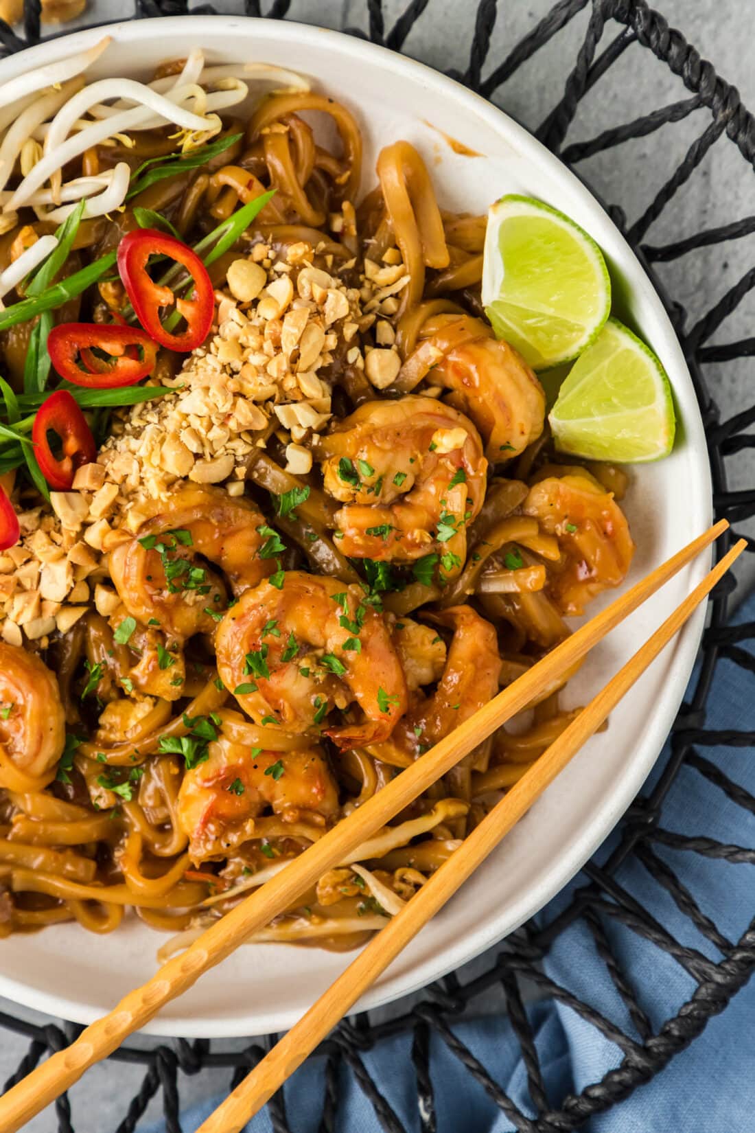 Close up photo of Shrimp Pad Thai in a bowl with chopsticks resting on the bowl
