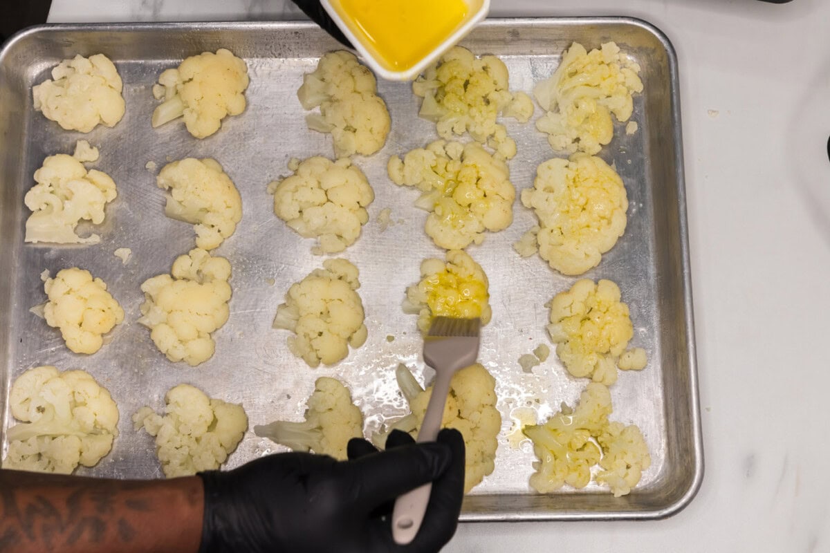 brushing oil on cauliflower florets