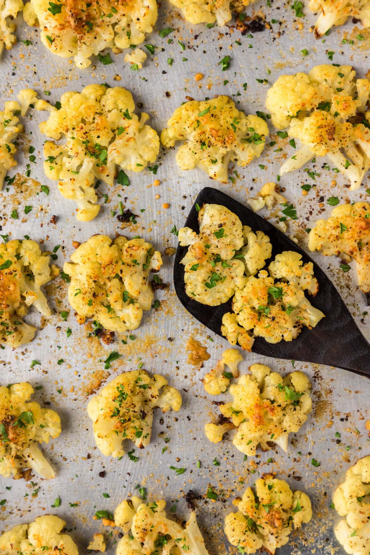 Close up photo of Smashed Cauliflower on a sheet pan with a spatula