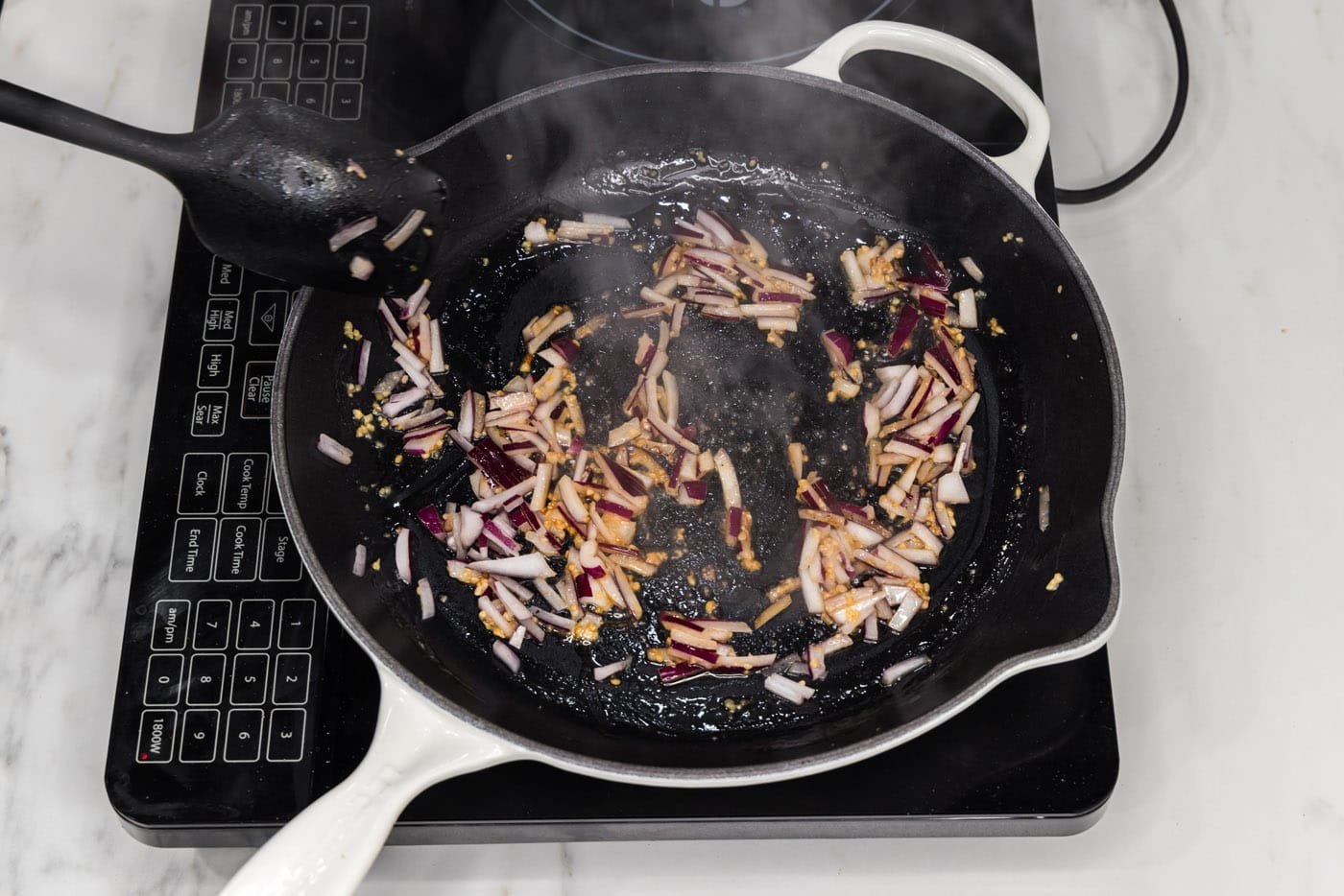 sauteeing red onion and garlic in a skillet