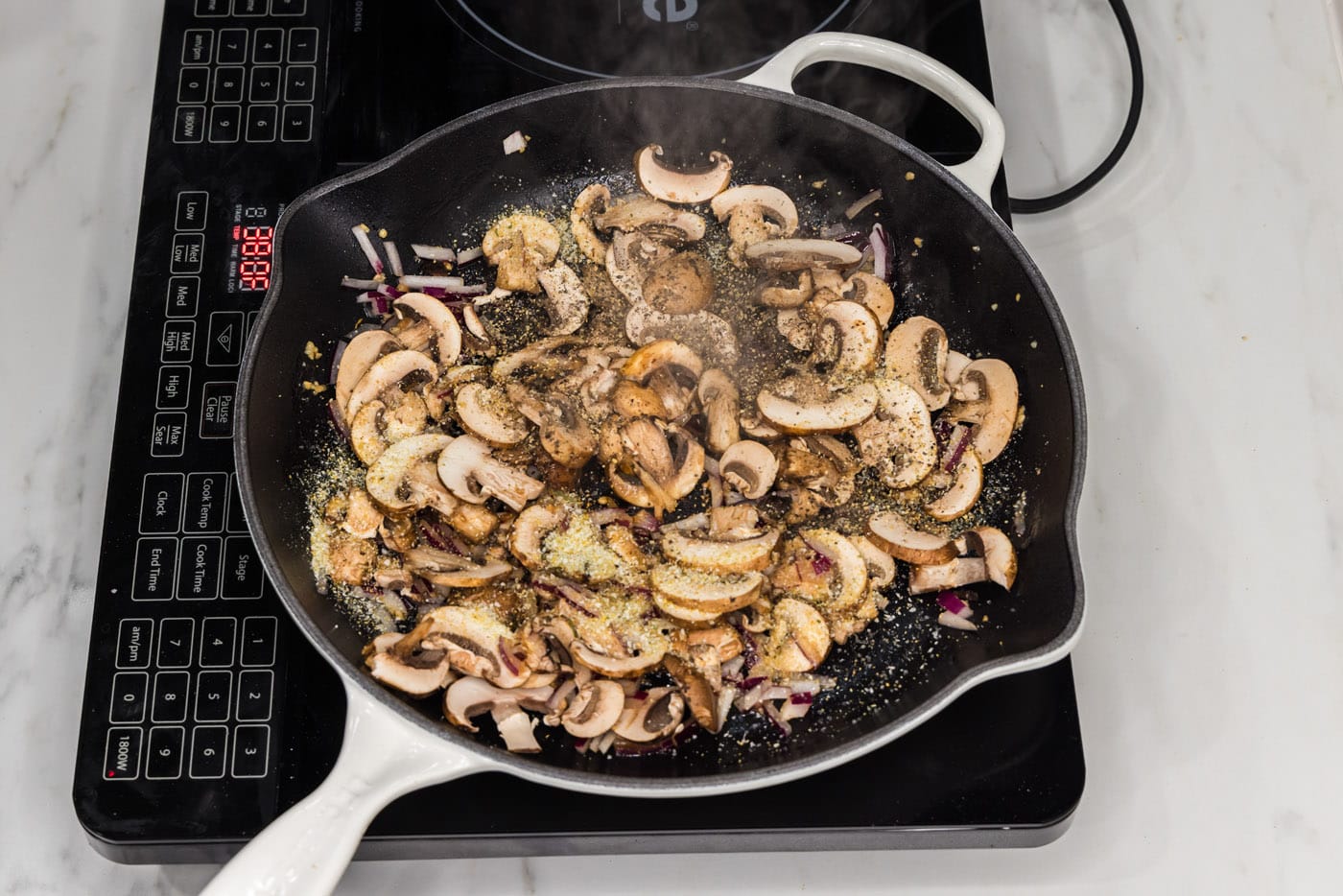 sliced mushrooms added to skillet with garlic and onion