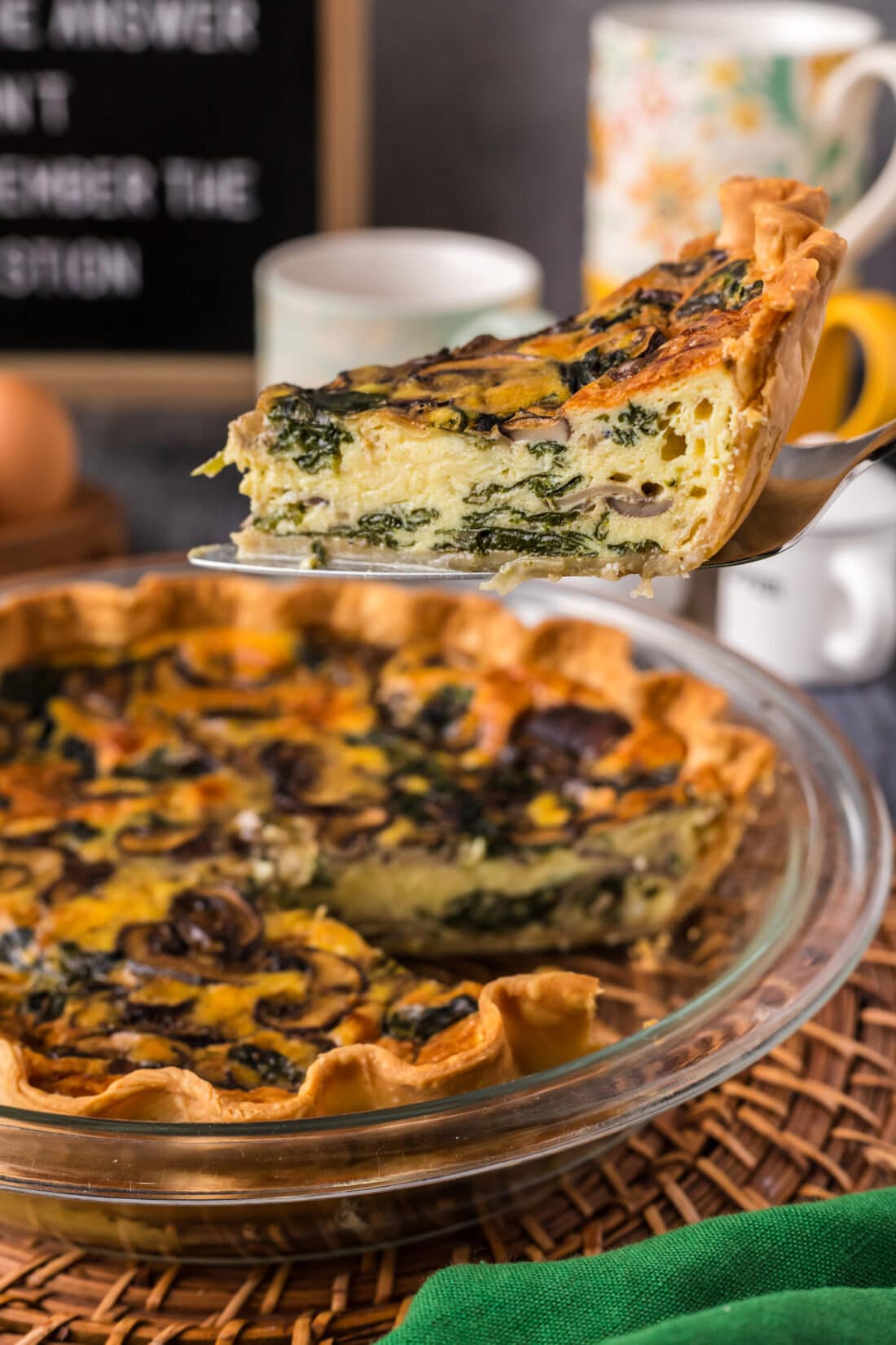Slice of Spinach Mushroom Quiche being lifted out of the pie plate