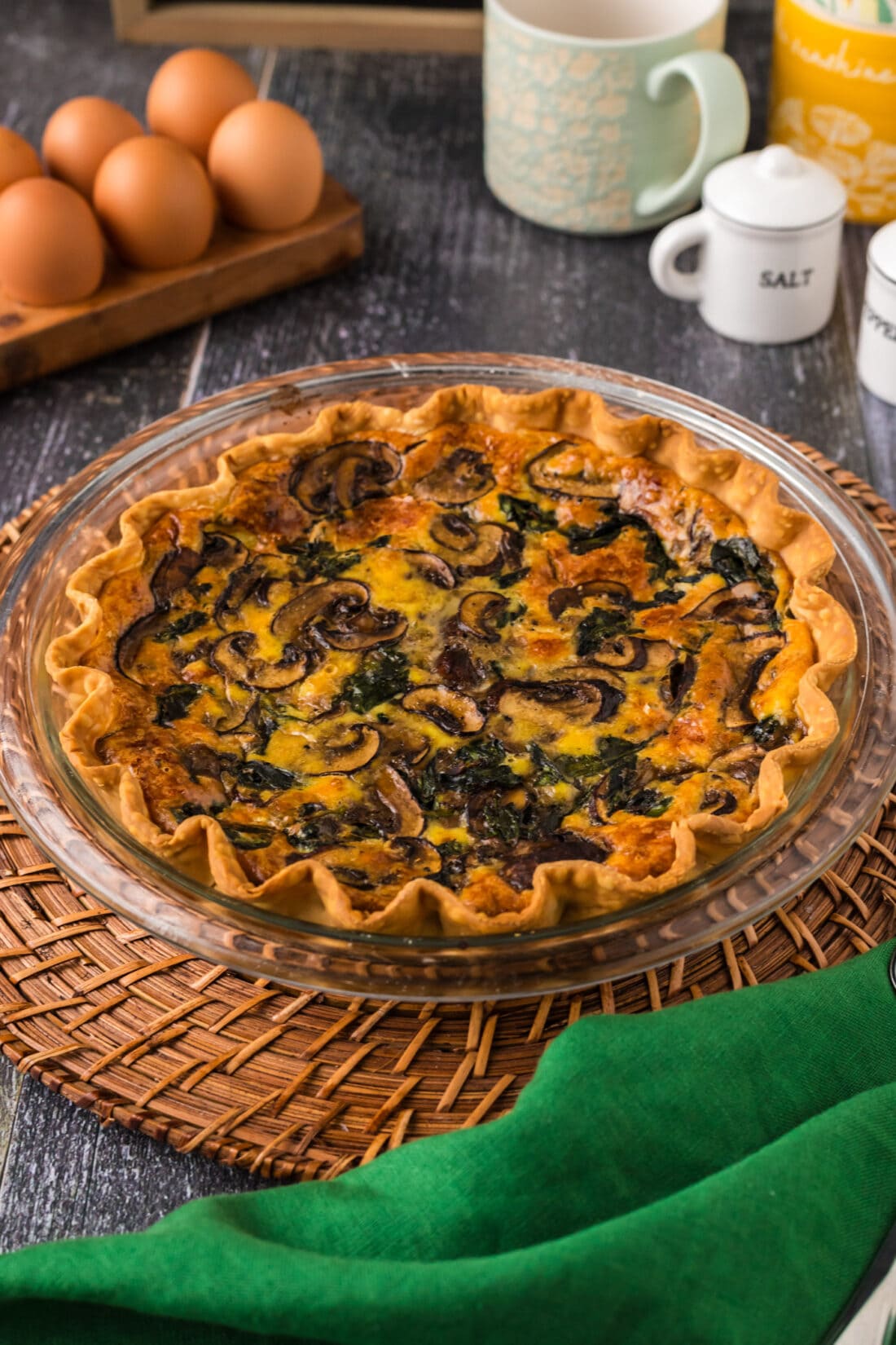Spinach Mushroom Quiche on a wooden charger