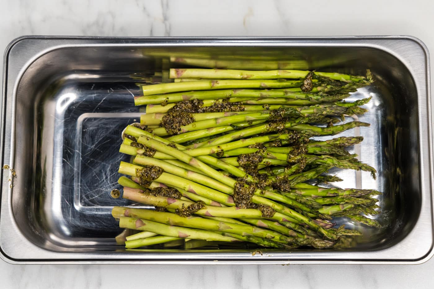 olive oil and seasonings on top of asparagus spears