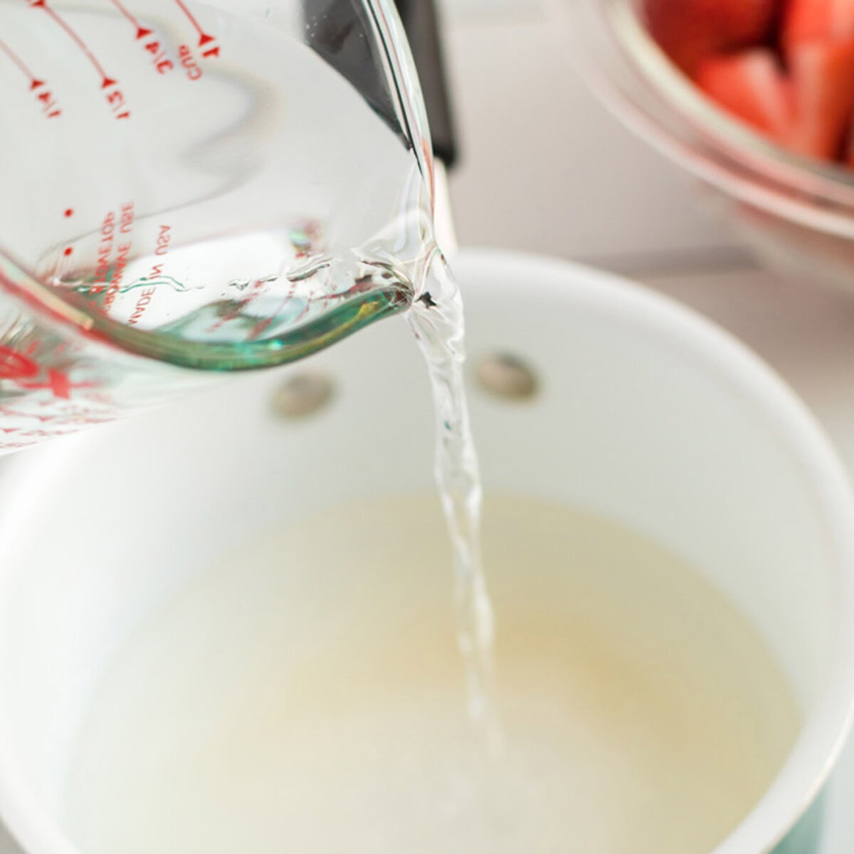 Water being poured into a bowl of of sugar and cornstarch