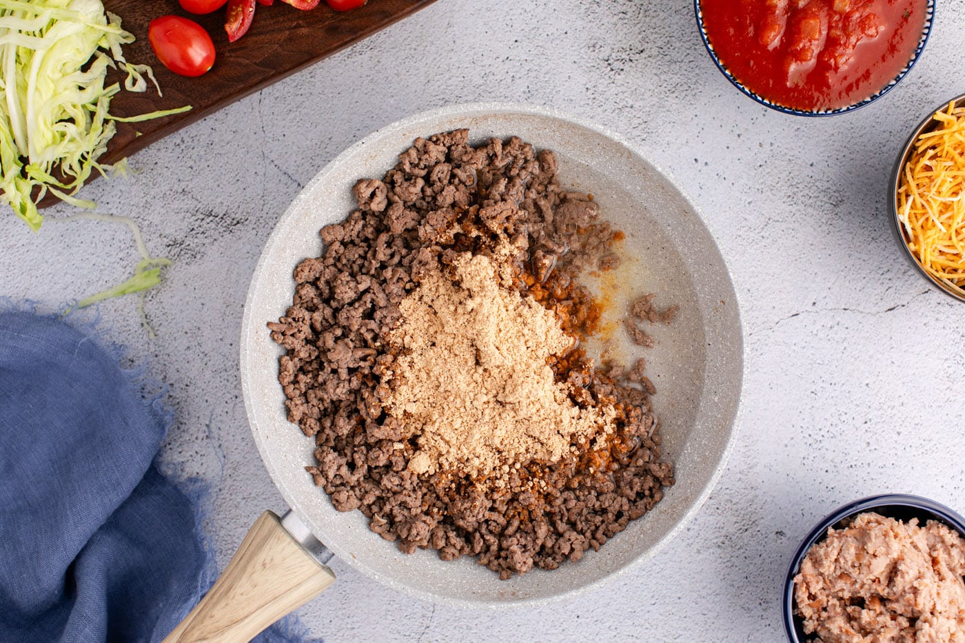 taco seasoning added to skillet with ground beef