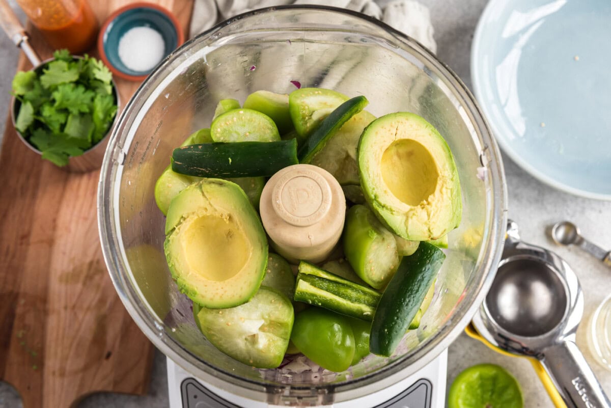 avocado and serrano chile pepper added to food processor with red onion