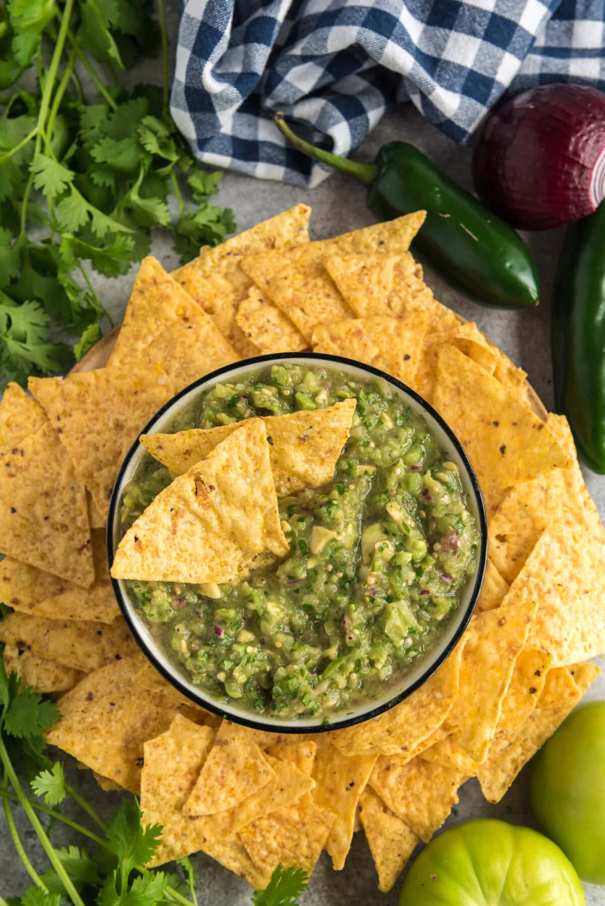 Overhead photo of a bowl of Tomatillo Onion Avocado Salsa with two chips in it