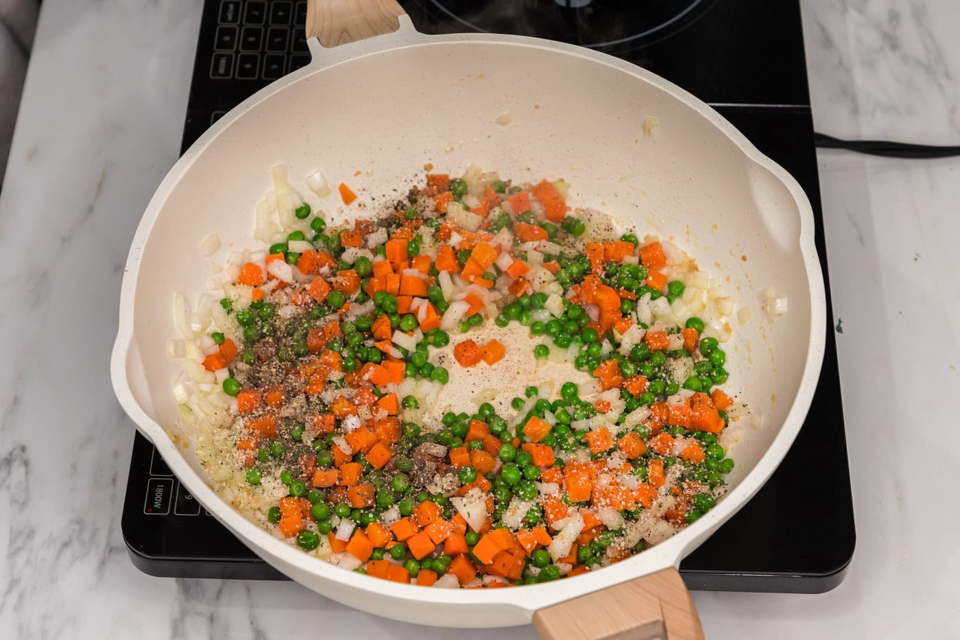 carrots, peas, and onion in a skillet with oil and garlic