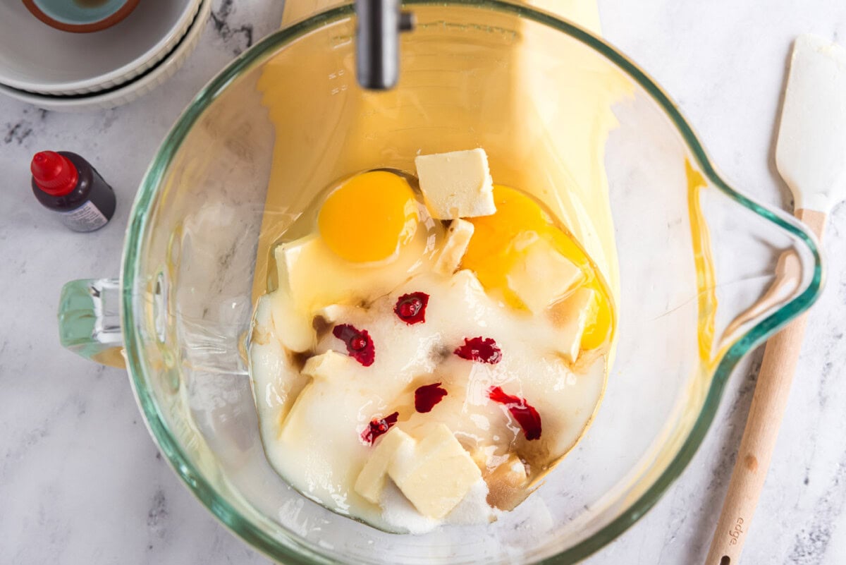 butter, eggs, sugar, and food coloring in a mixer bowl