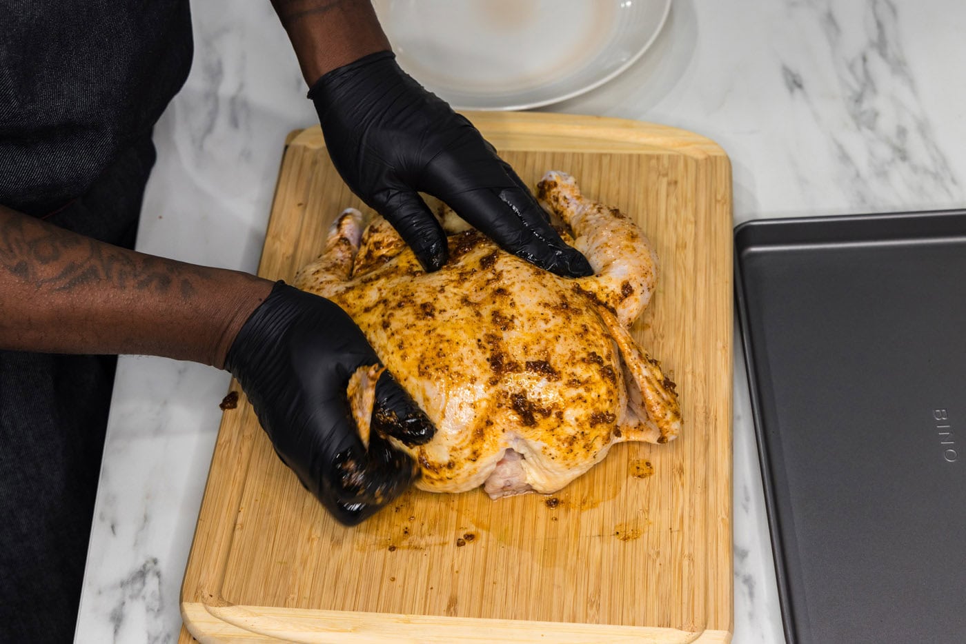 rubbing oil and seasonings over whole chicken