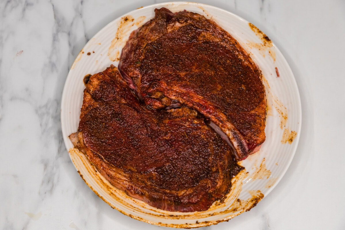 seasoned ribeye steaks on a plate