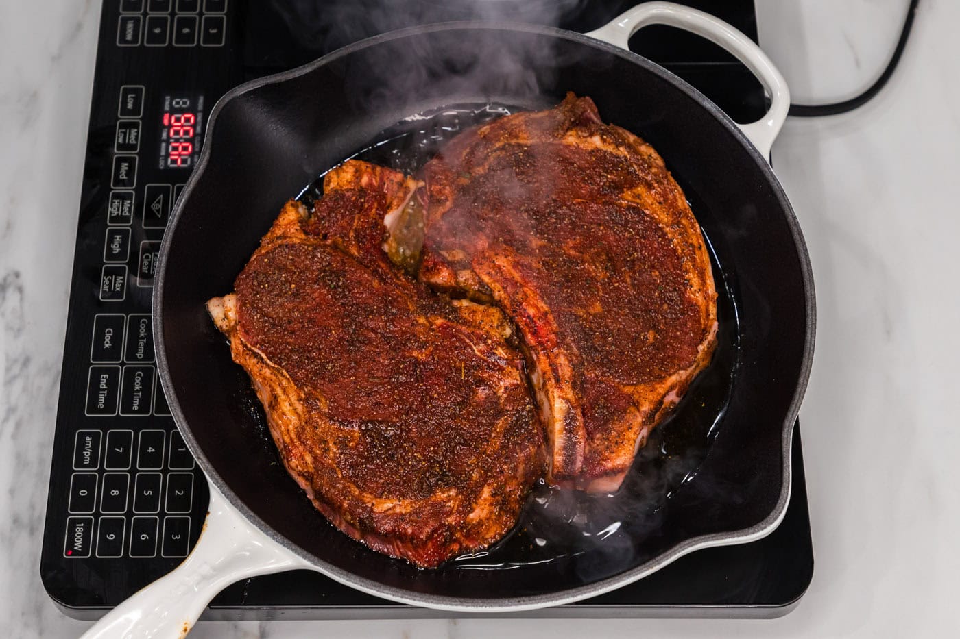 searing ribeye steaks in a skillet