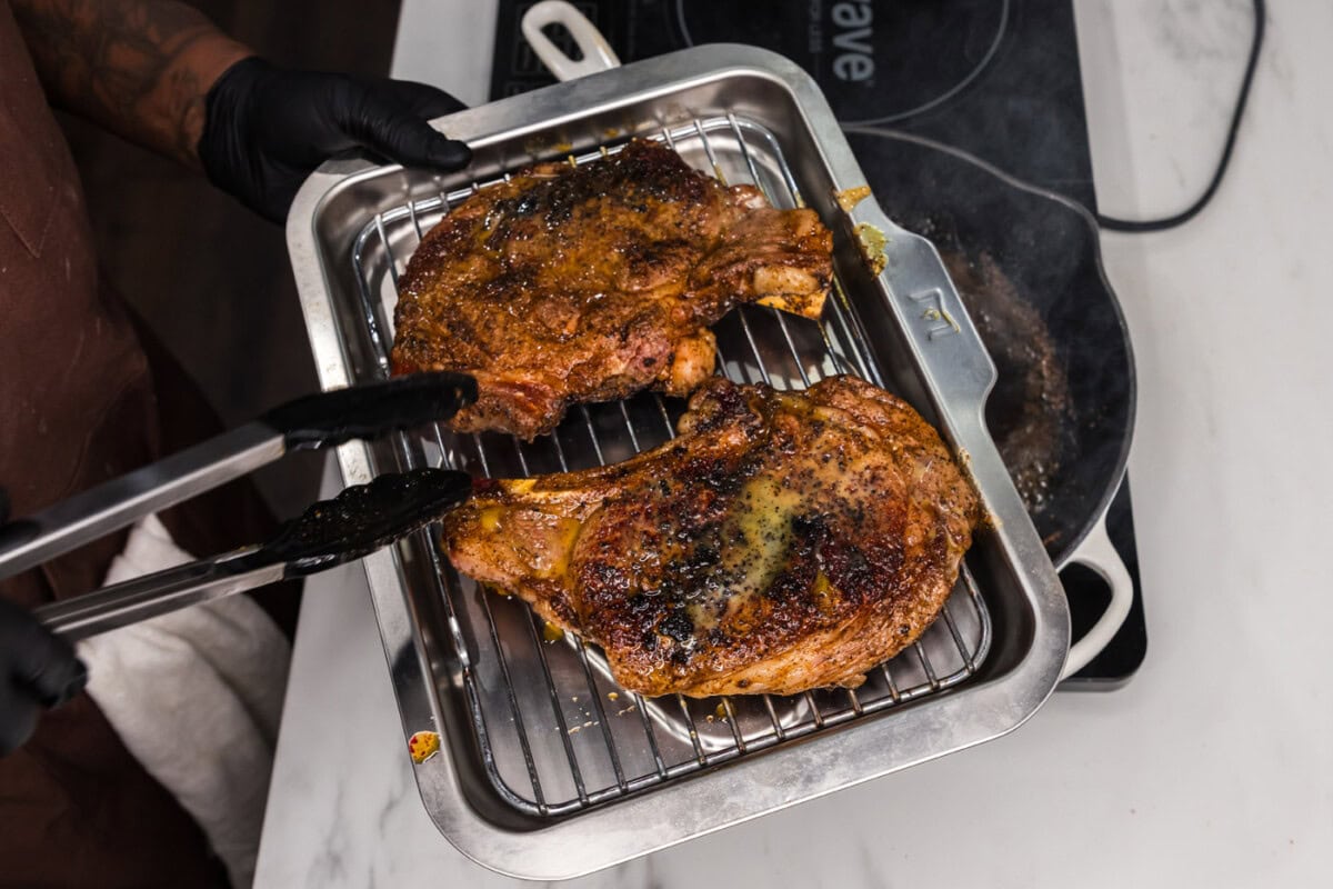 transferring ribeye steaks to a baking sheet