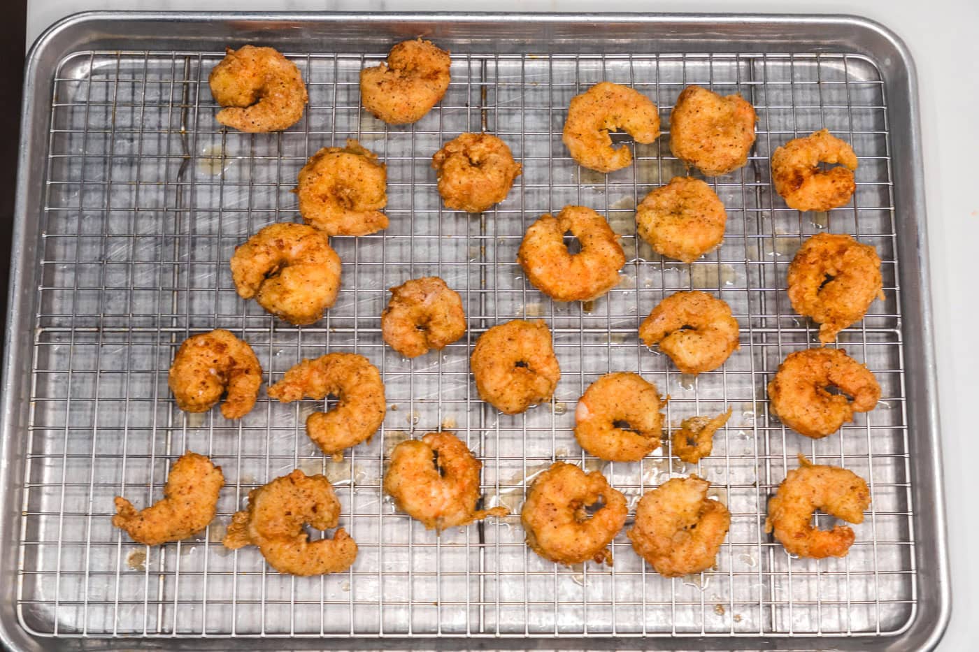 fried shrimp on a wire rack draining