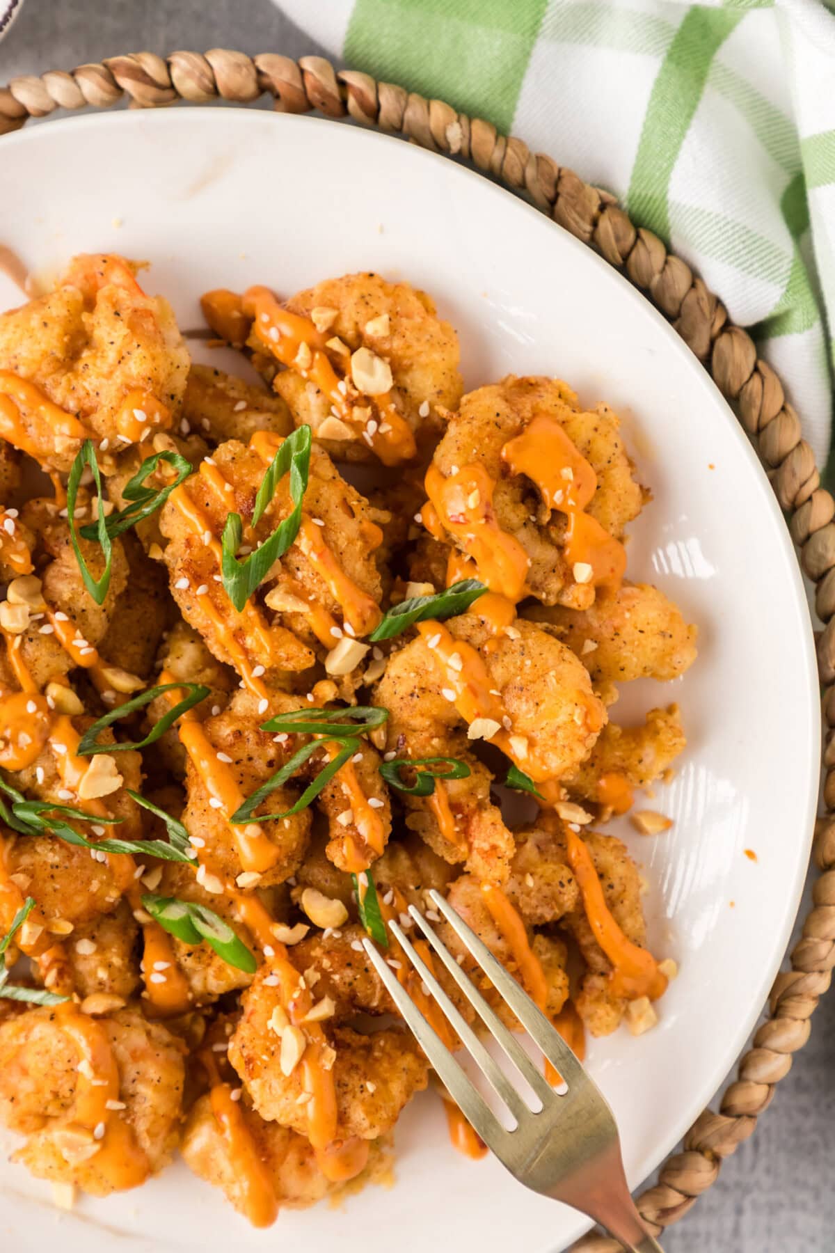 Half a plate of Boom Boom Shrimp with a fork on the side