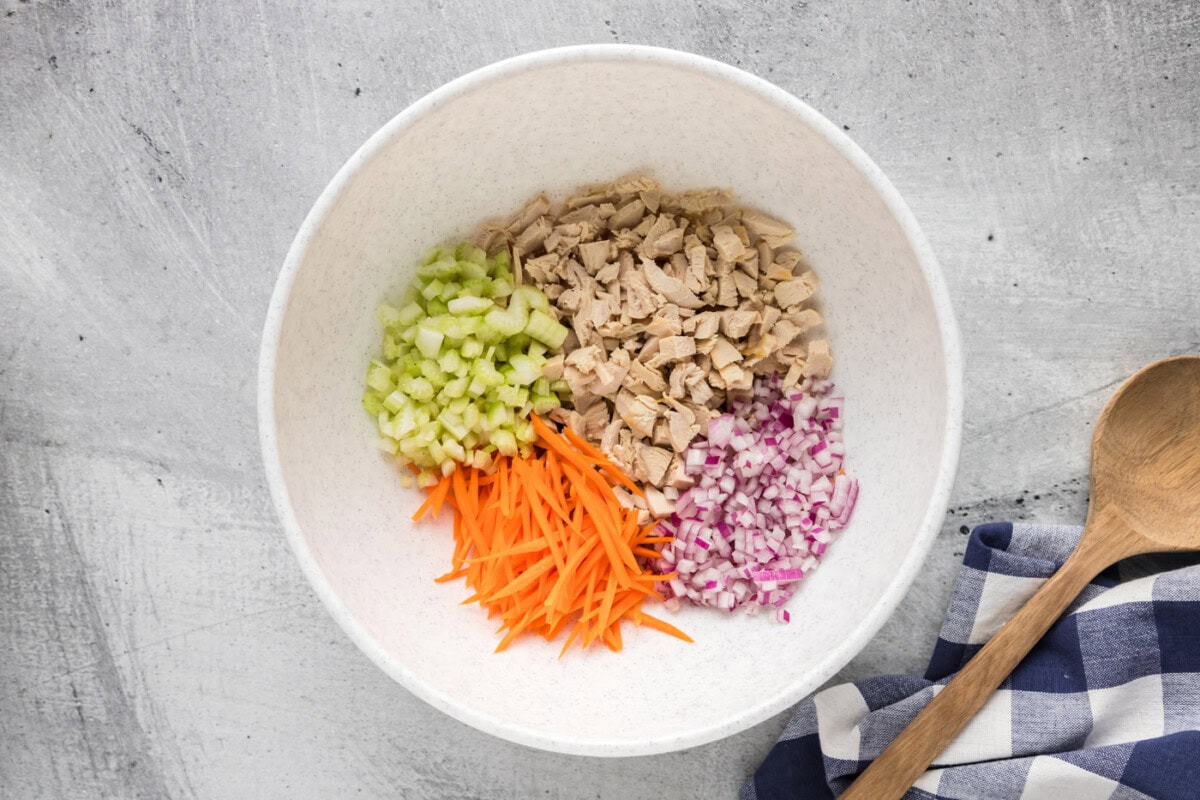 chopped chicken, celery, onion, and carrots in a mixing bowl