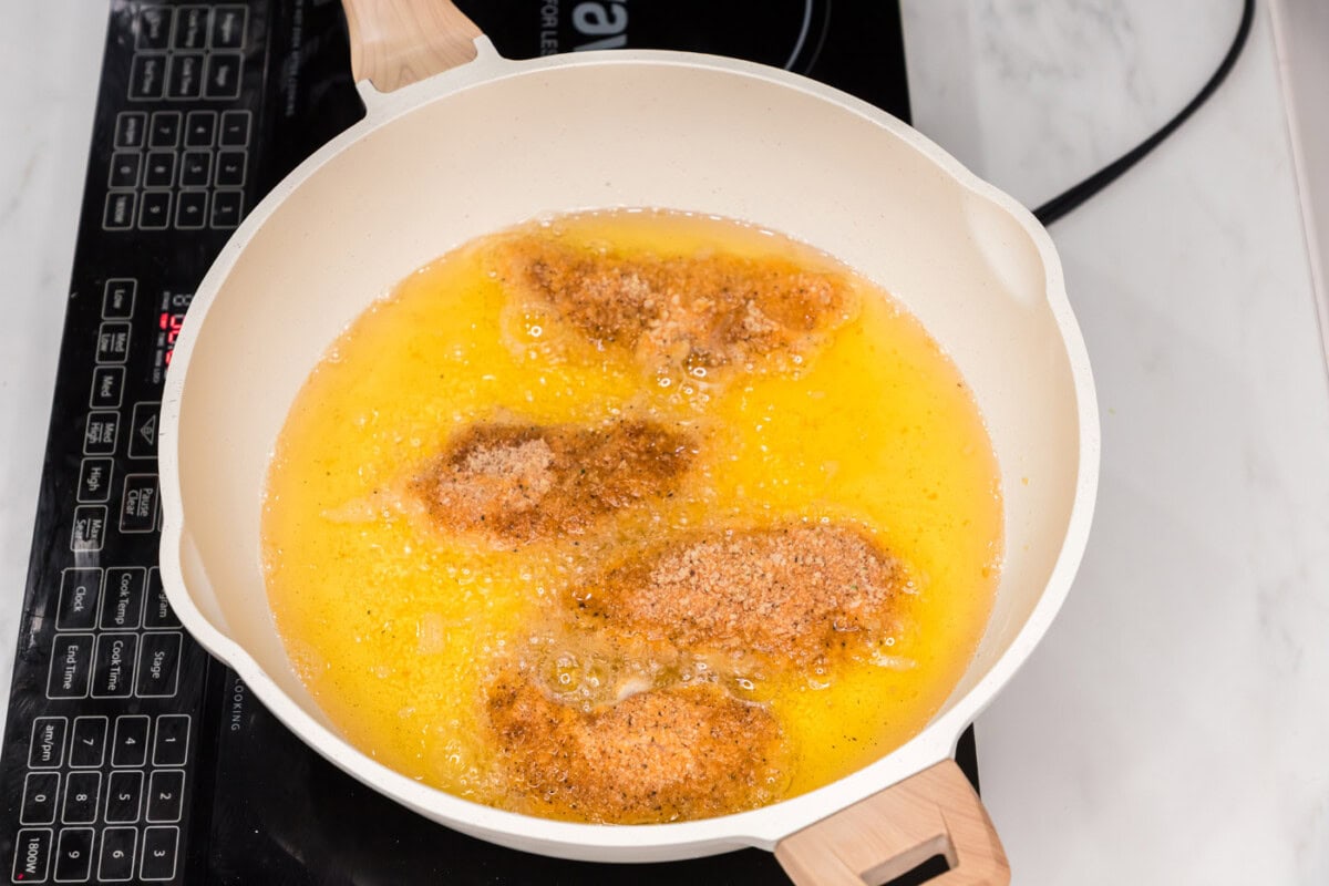frying buffalo chicken tenders in a skillet of oil