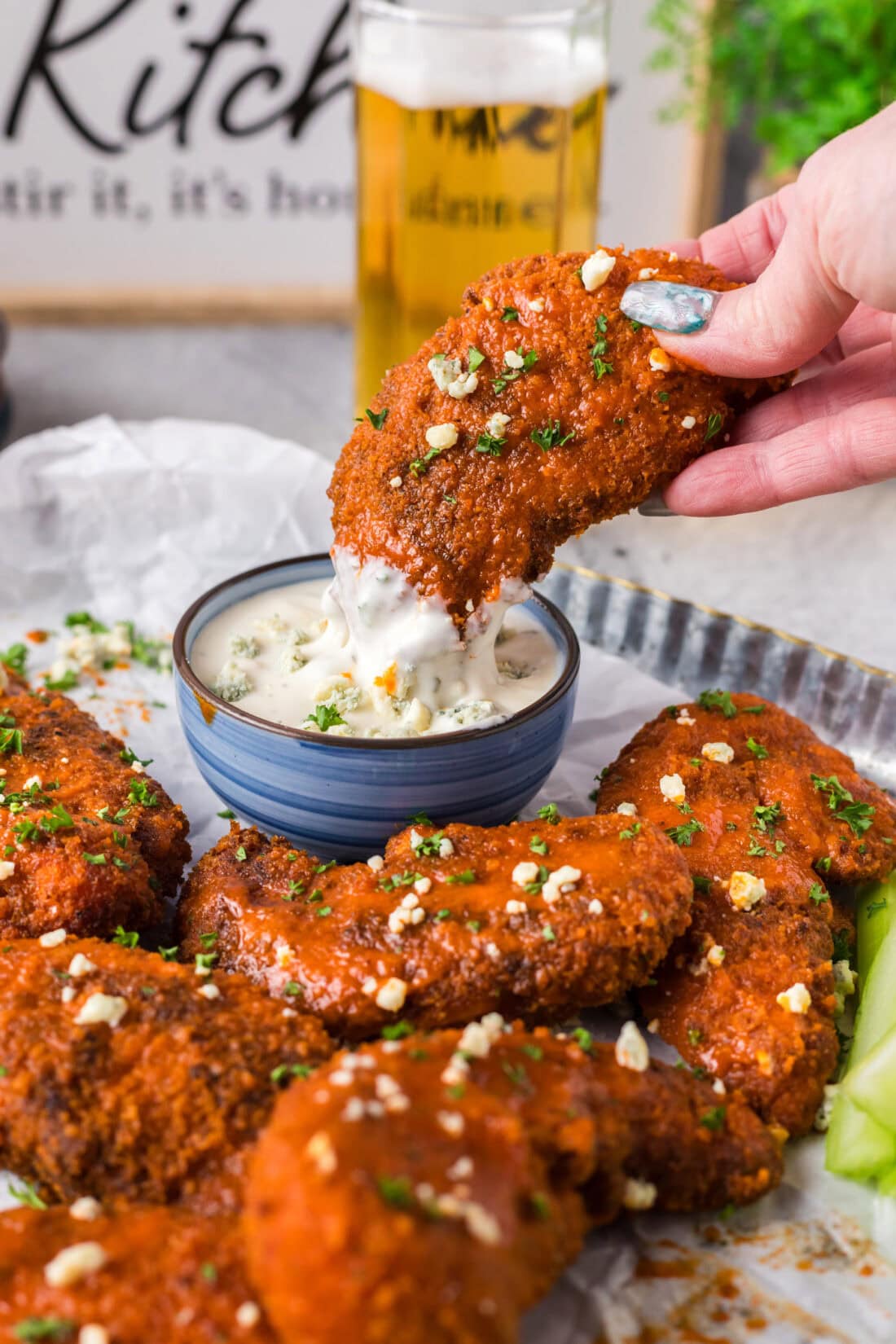 Buffalo Chicken Tender being dipped into blue cheese dressing