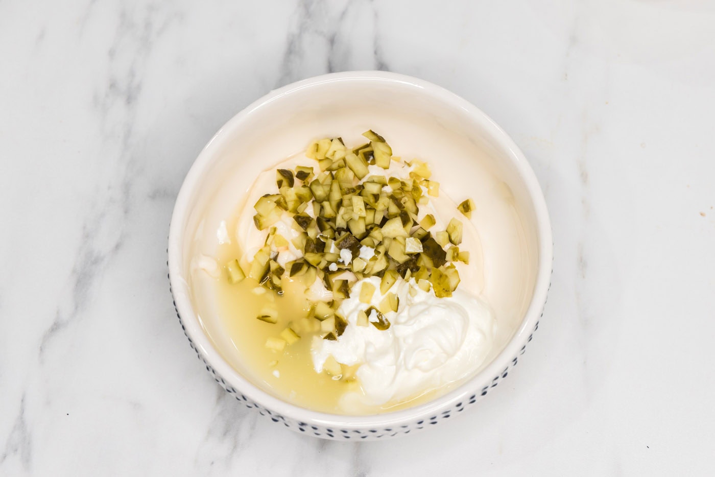 diced pickles, mayo, sour cream, and lemon juice in a bowl